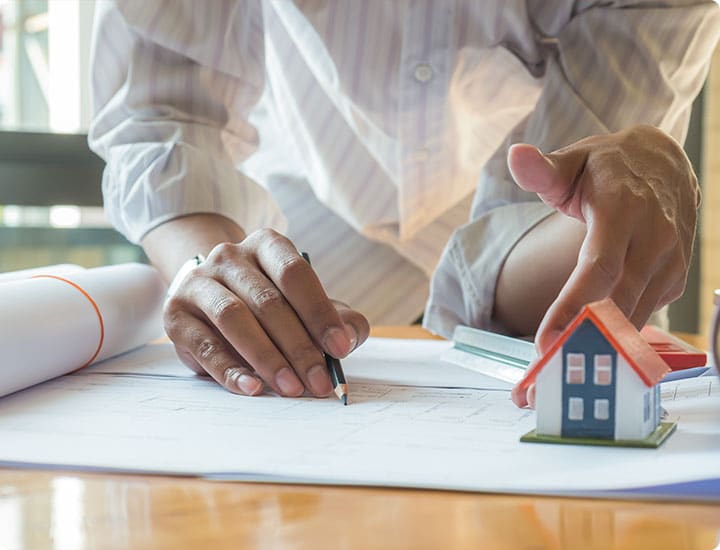 MUJER DIBUJANDO UN PLANO Y CASAS
