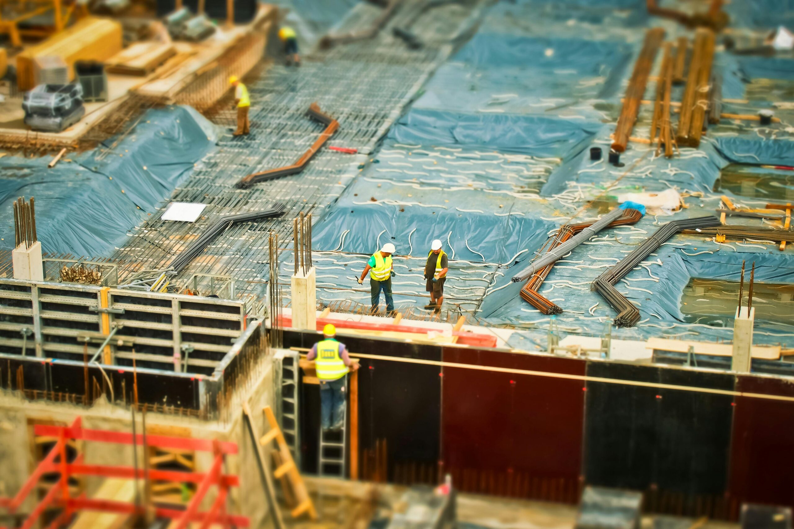 CONSTRUCCIÓN CON MUCHOS TRABAJADORES Y UN SUELO AZUL